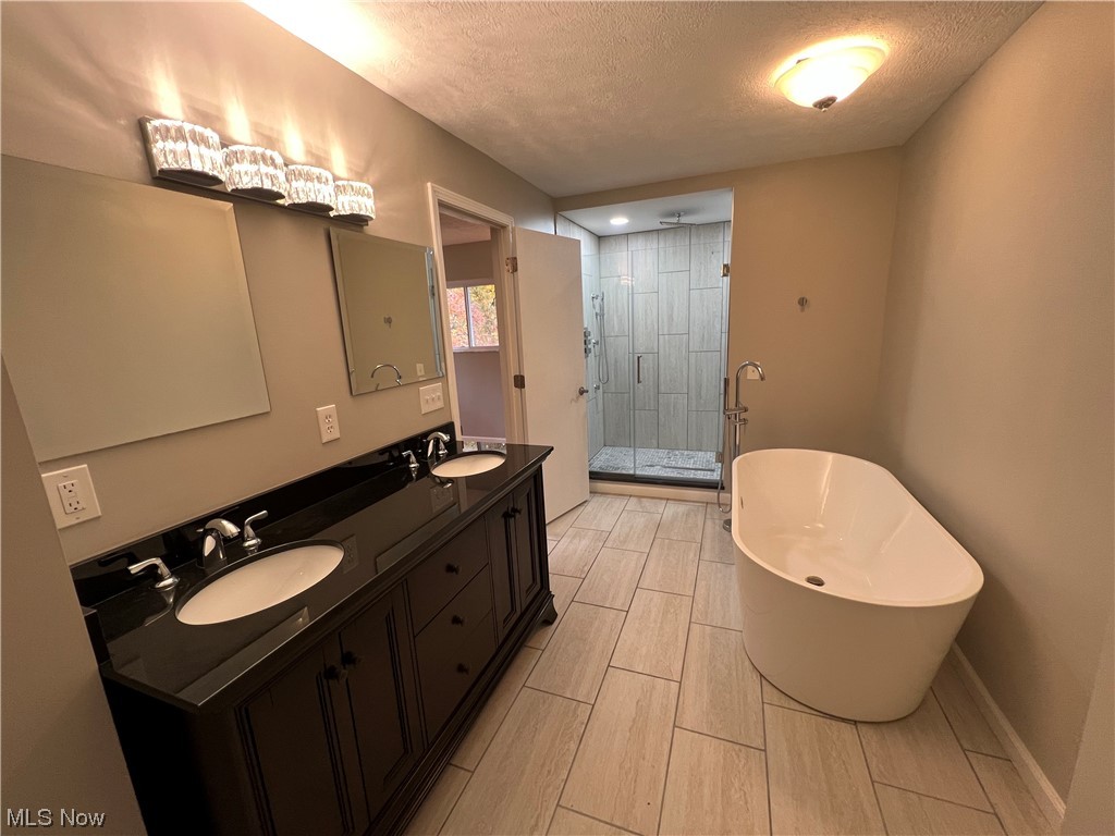 5105 Hillside Road Independence, OH 44131 - Photo 18 of 35 Bathroom with plus walk in shower, a textured ceiling, tile floors, and double sink vanity