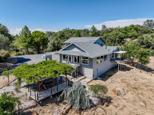 a kitchen with stainless steel appliances granite countertop a stove and a view of living room