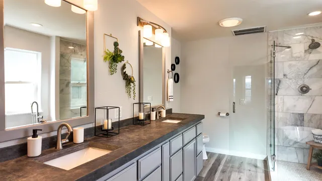 a bathroom with a granite countertop sink a mirror a vanity and a shower