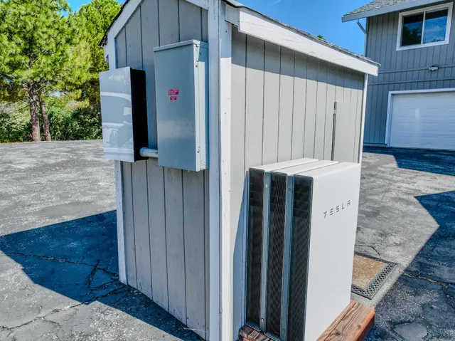 an empty room with a chandelier fan and windows