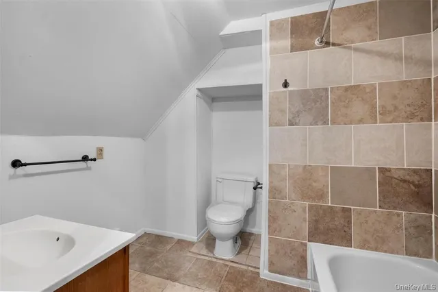 a bathroom with a tub sink and mirror