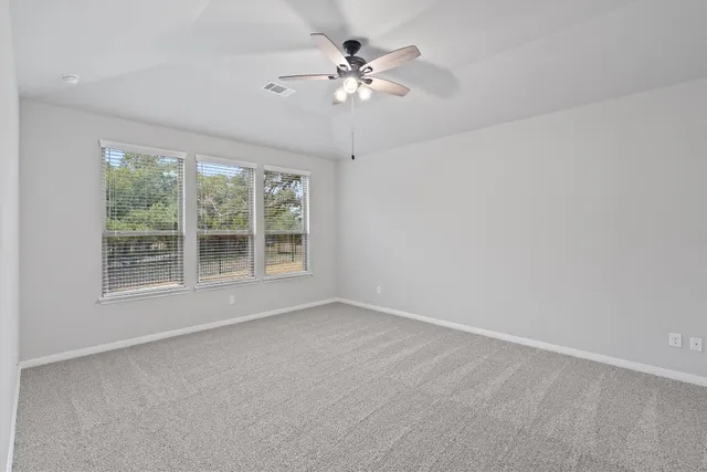 a view of an empty room with a ceiling fan
