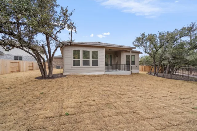 a view of backyard with wooden fence