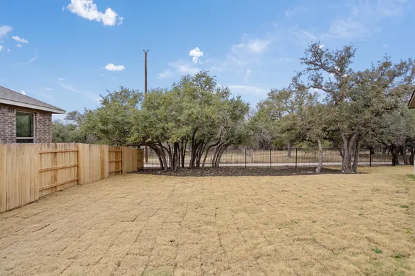 a view of backyard with wooden fence