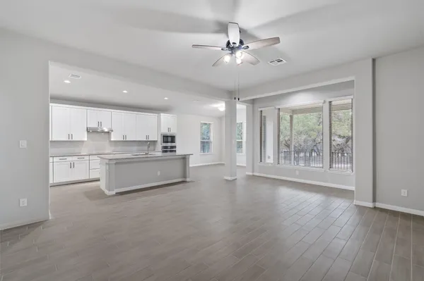 a large white kitchen with wooden floor and a sink