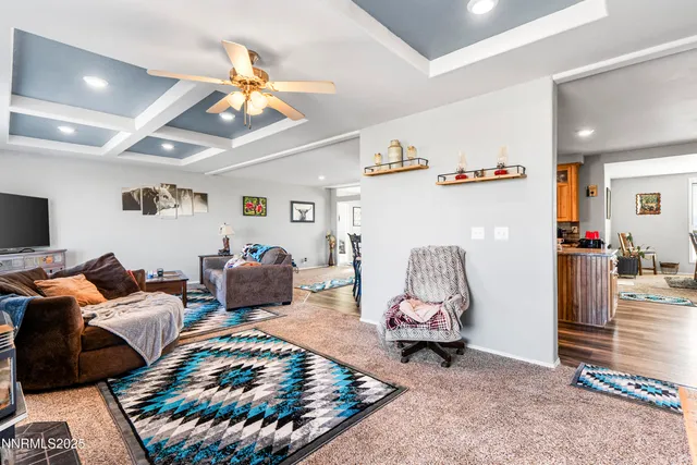a living room with furniture a kitchen view and a chandelier