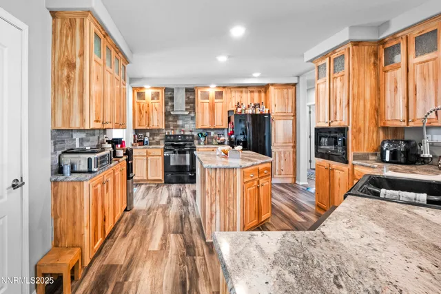 a kitchen with stainless steel appliances granite countertop sink stove top oven and cabinets