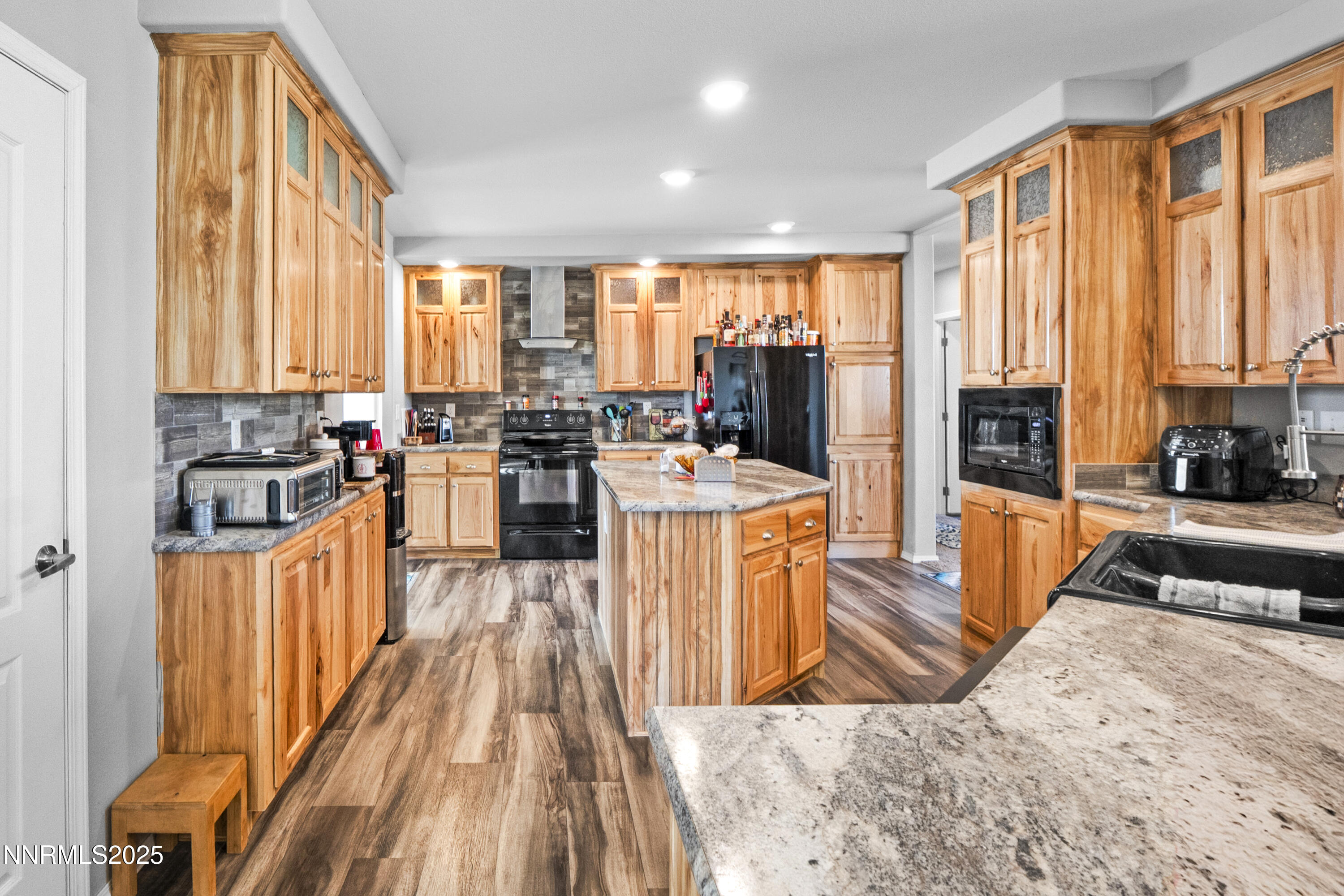 6745 Country Road Winnemucca, NV 89445 - Photo 9 of 50 a kitchen with stainless steel appliances kitchen island granite countertop a refrigerator a stove a sink dishwasher a couches with wooden cabinets and wooden floor
