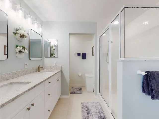 a spacious bathroom with a granite countertop sink a mirror and a shower