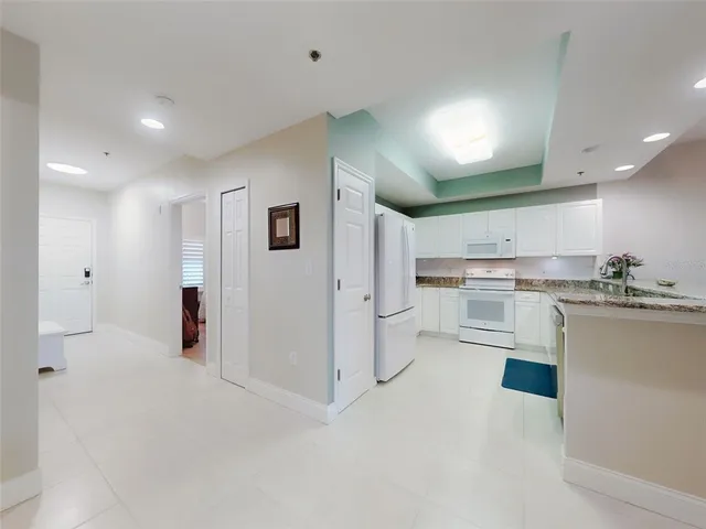 a kitchen with stainless steel appliances granite countertop a refrigerator a stove and a sink