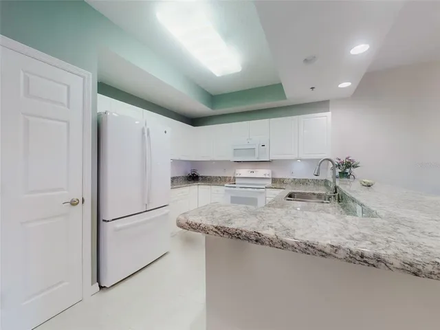 a kitchen with granite countertop a sink stainless steel appliances and cabinets