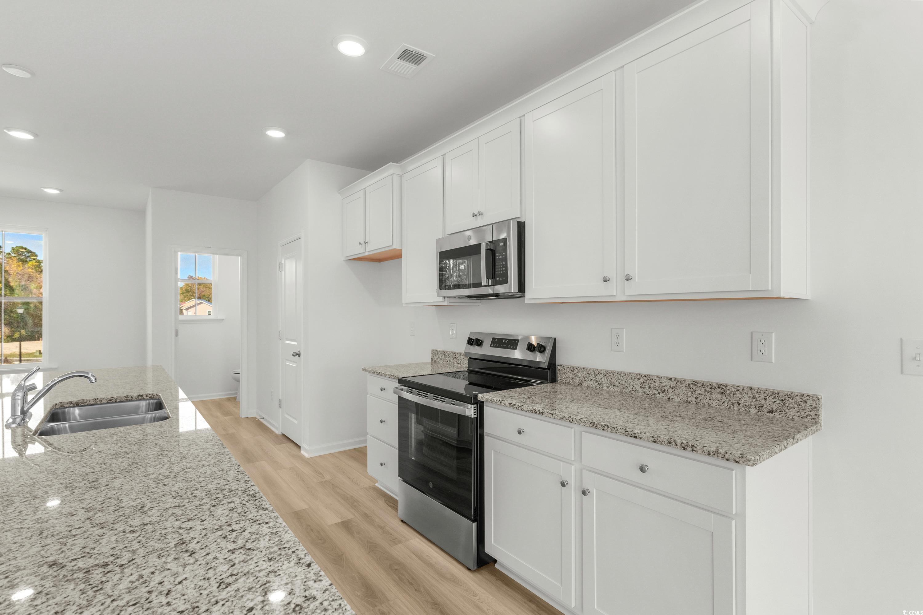 4414 Kingsport Road, Unit 1502 Little River, SC 29566 - Photo 10 of 33 Kitchen featuring appliances with stainless steel finishes, light wood finished floors, white cabinetry, and recessed lighting
