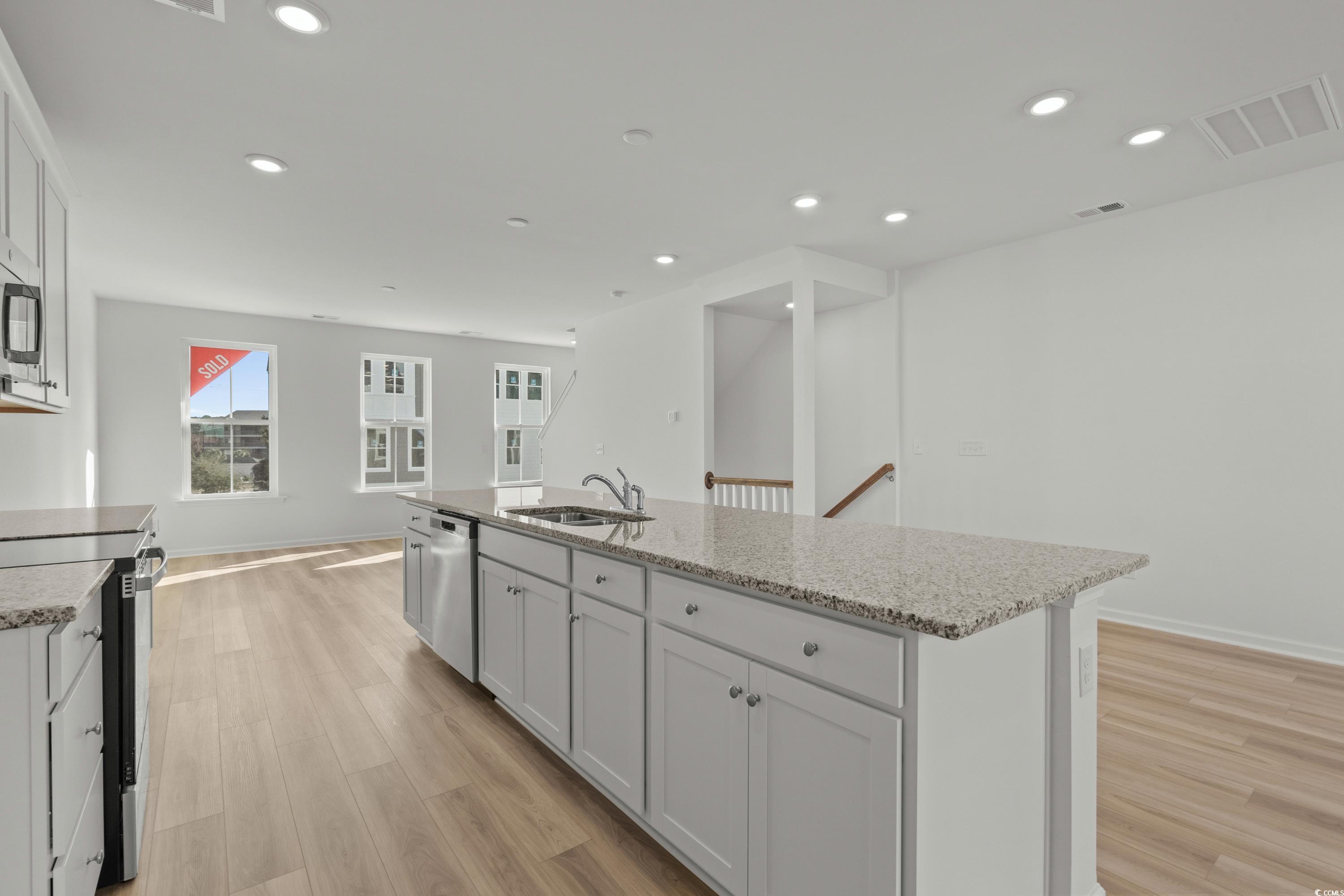 4414 Kingsport Road, Unit 1502 Little River, SC 29566 - Photo 11 of 33 Kitchen with light stone countertops, stainless steel appliances, white cabinetry, recessed lighting, and light wood-type flooring