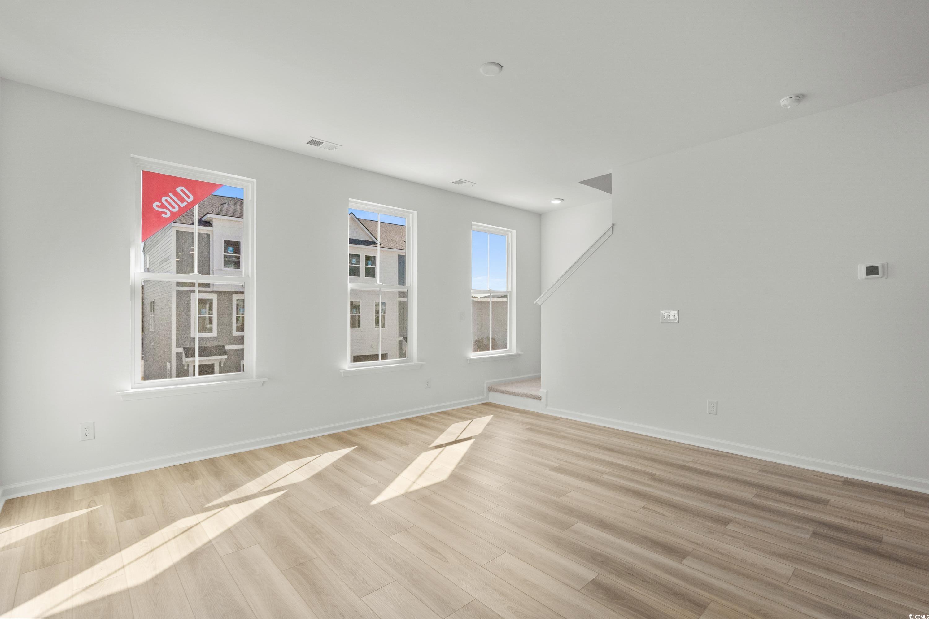 4414 Kingsport Road, Unit 1502 Little River, SC 29566 - Photo 12 of 33 Kitchen featuring a kitchen island with sink, light stone counters, electric range, white cabinets, and light wood-type flooring