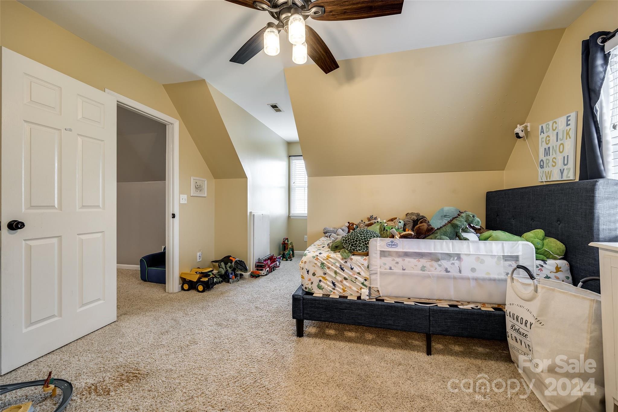 9999 Jim Sossoman Road Midland, NC 28107 - Photo 24 of 43 a bedroom with a bed and a chandelier