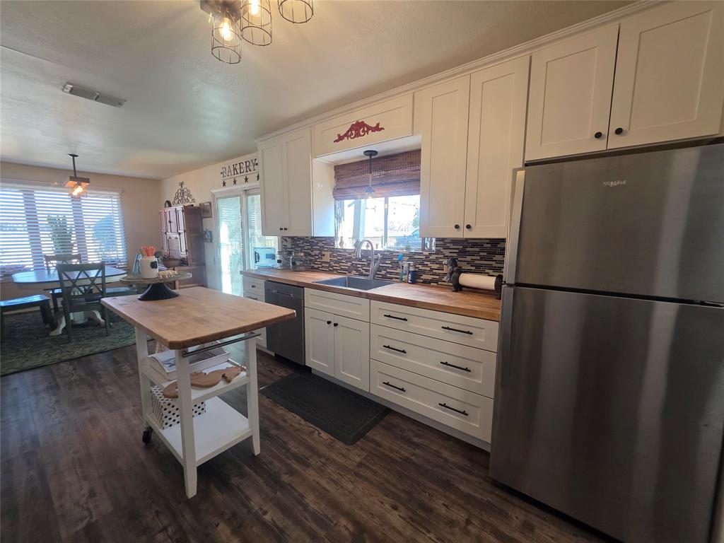 1301 Cliff Drive Graham, TX 76450 - Photo 18 of 38 a kitchen with a refrigerator a stove a sink dishwasher and wooden cabinets with wooden floor