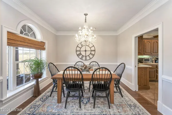 a view of a dining room with furniture a chandelier and wooden floor