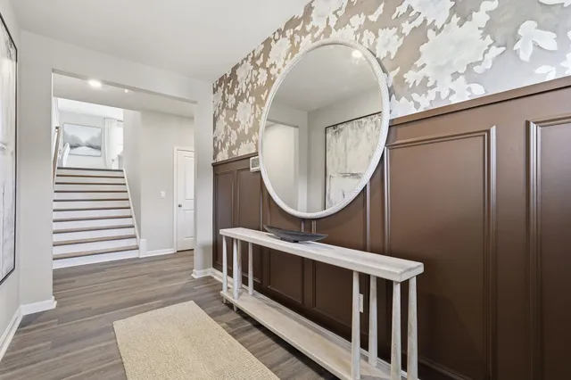 a living room with furniture a mirror and a wooden floor