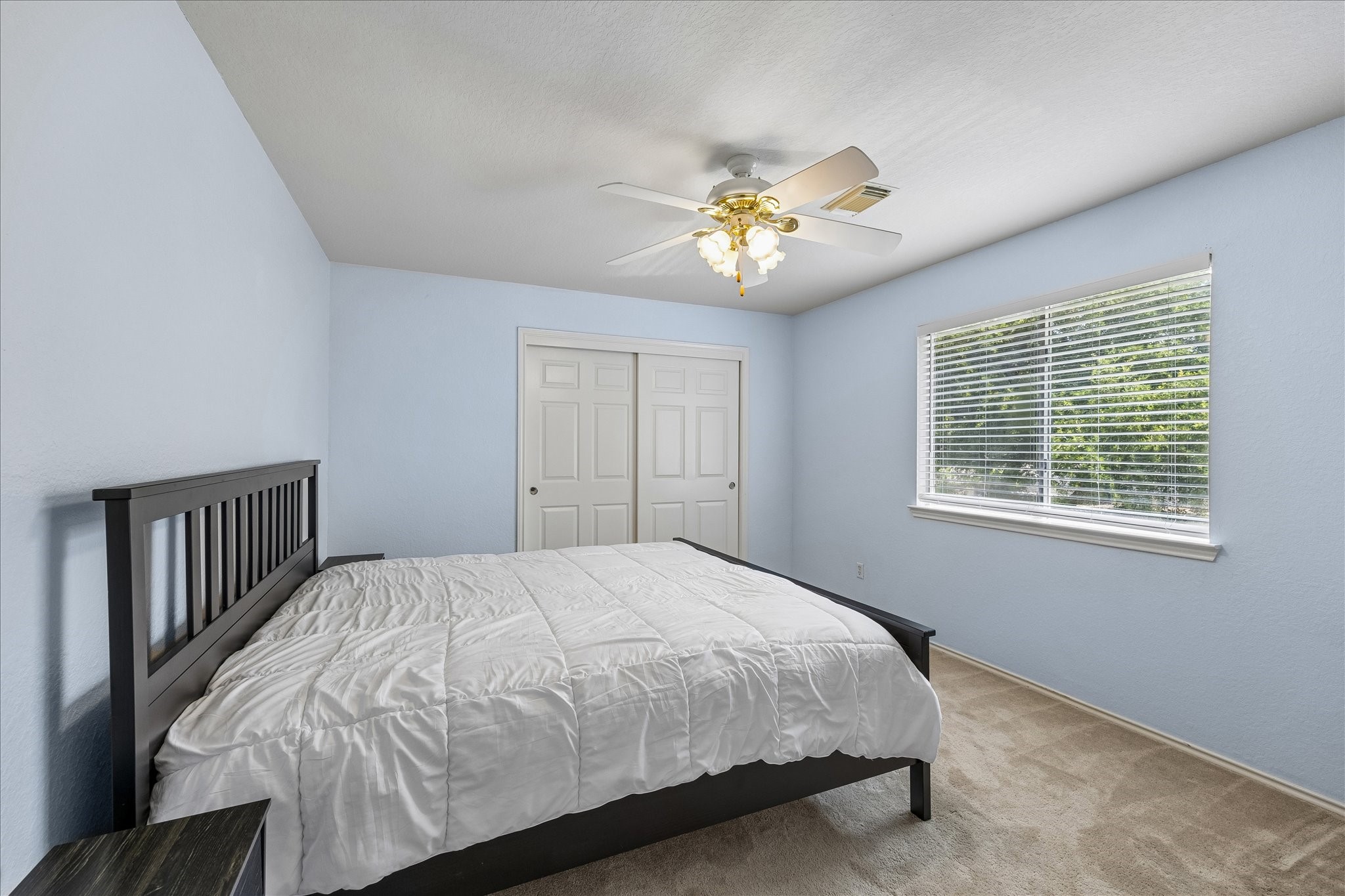 23234 Grand Rapids Lane Spring, TX 77373 - Photo 25 of 30 Serene secondary bedroom offers soft blue tones, a spacious closet, and large windows filling the room with natural light.