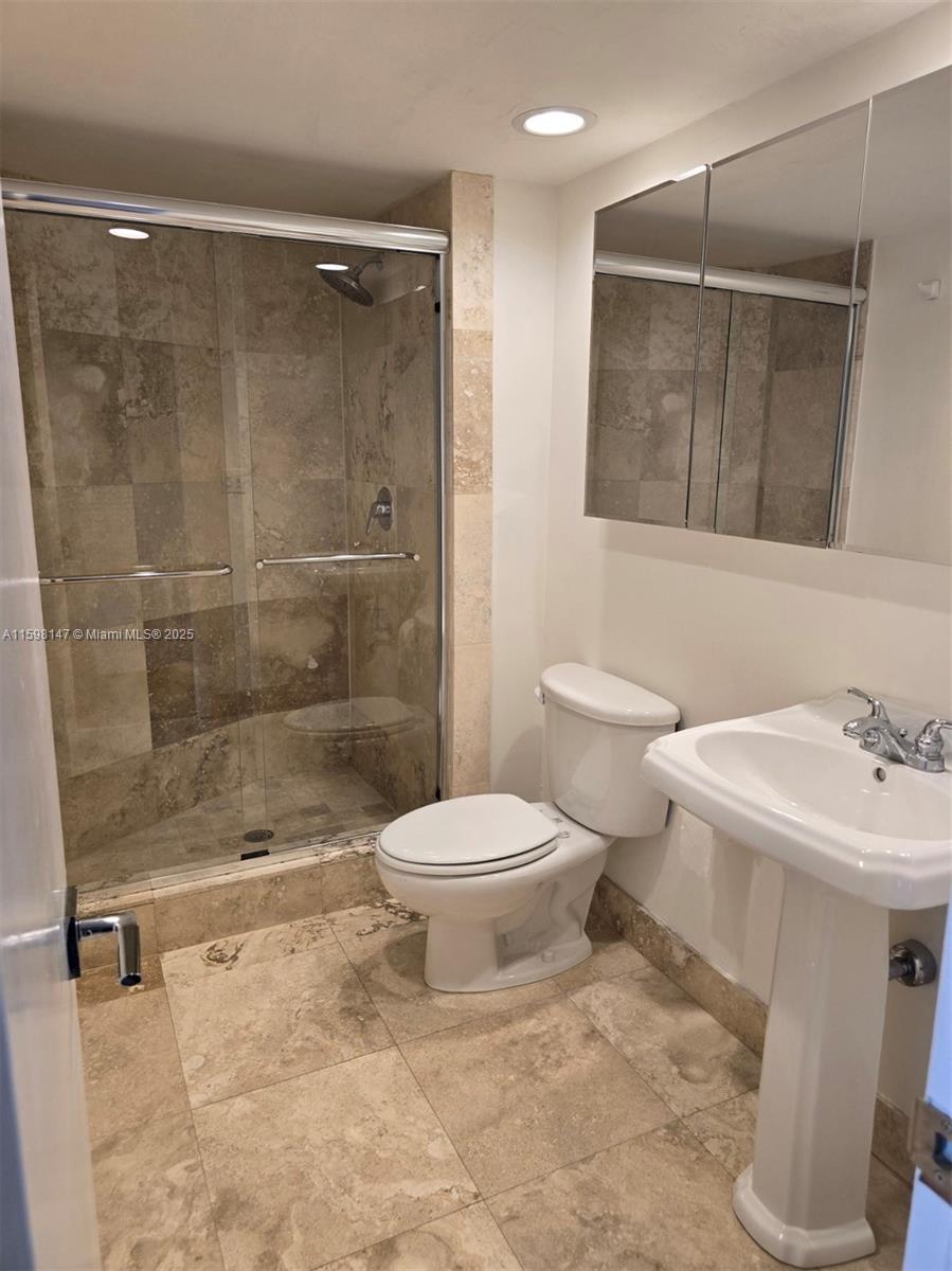 1121 Crandon Boulevard, Unit D604 Key Biscayne, FL 33149 - Photo 17 of 31 a bathroom with a toilet sink and shower