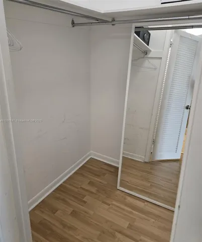 a view of walk in closet with wooden floor