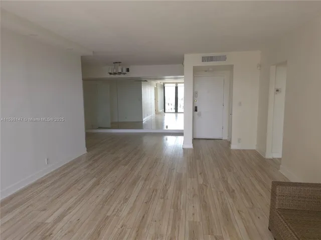 a view of a room with wooden floor and window