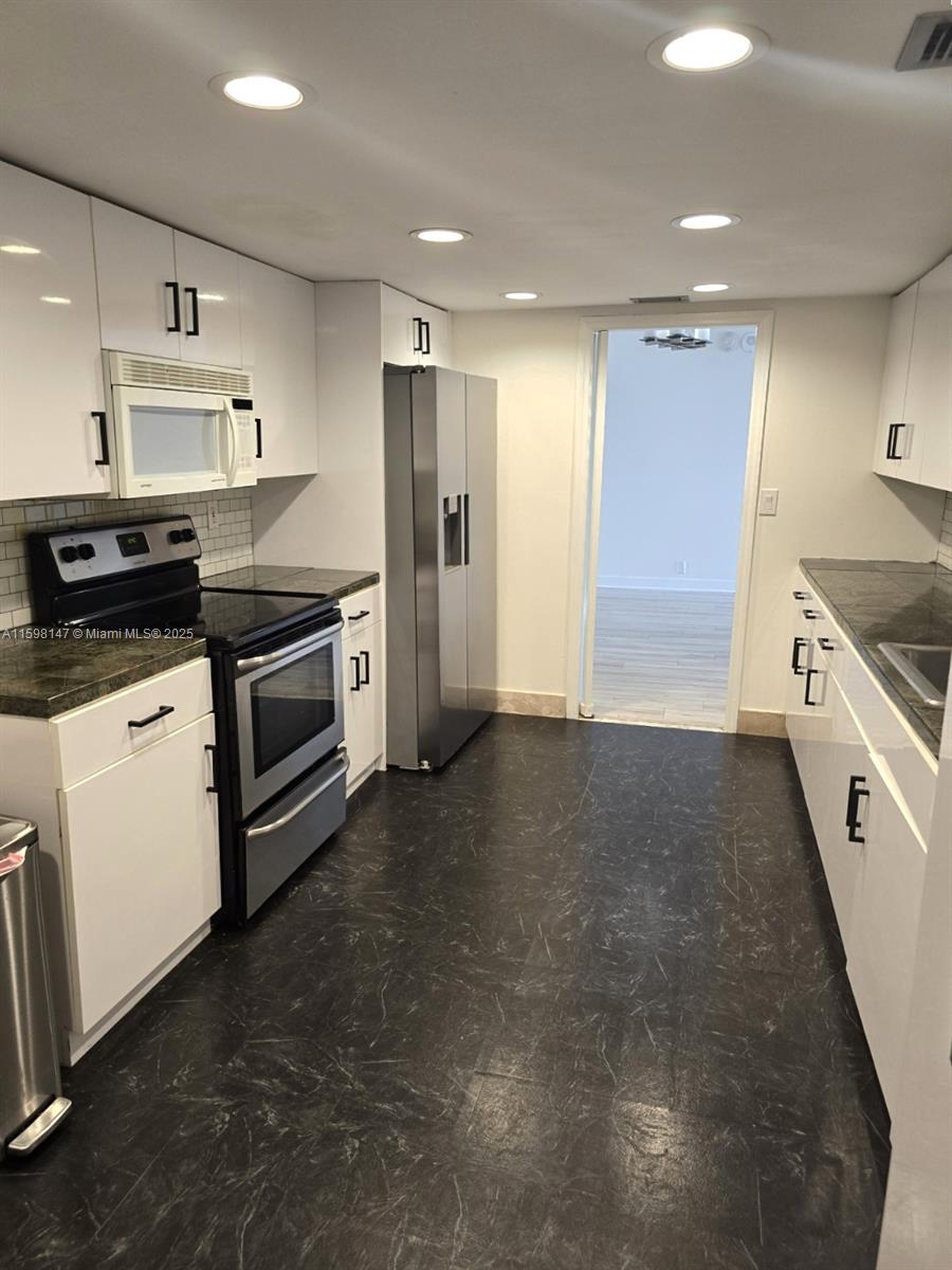 1121 Crandon Boulevard, Unit D604 Key Biscayne, FL 33149 - Photo 8 of 31 a kitchen with stainless steel appliances granite countertop a stove and a refrigerator