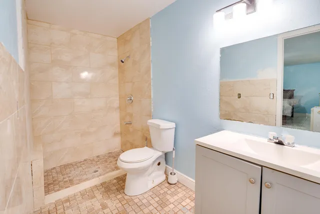 a bathroom with a sink a toilet and shower