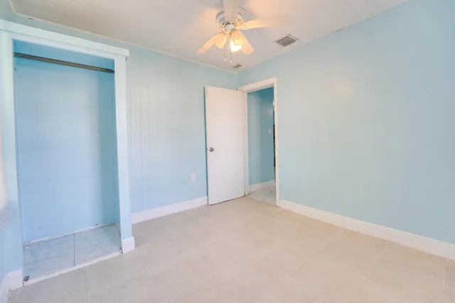 an empty room with a chandelier fan