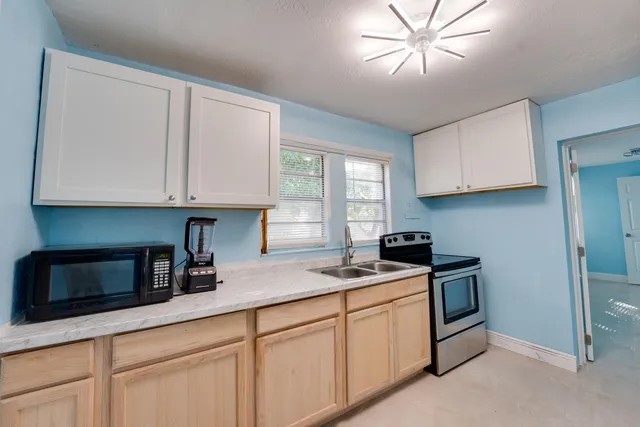 a kitchen with stainless steel appliances granite countertop a sink a stove and a microwave