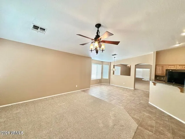 a view of a livingroom with a ceiling fan a kitchen space with a sink