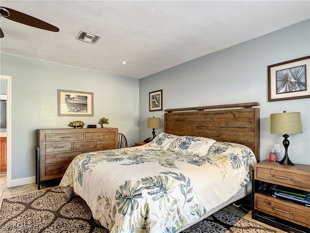 8065 Lagoon Road Fort Myers Beach, FL 33931 - Photo 18 of 28 a bedroom with a bed and wooden floor