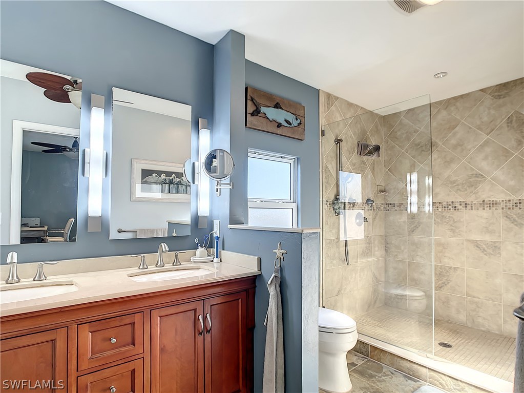 8065 Lagoon Road Fort Myers Beach, FL 33931 - Photo 19 of 28 a bathroom with a granite countertop sink toilet and shower