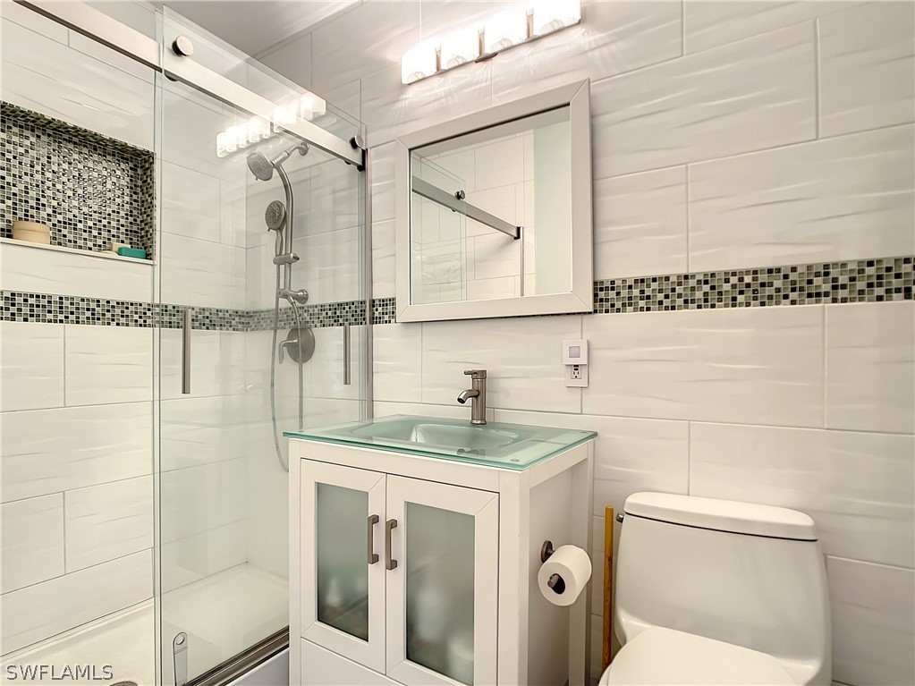 8065 Lagoon Road Fort Myers Beach, FL 33931 - Photo 21 of 28 a bathroom with a granite countertop sink toilet and shower
