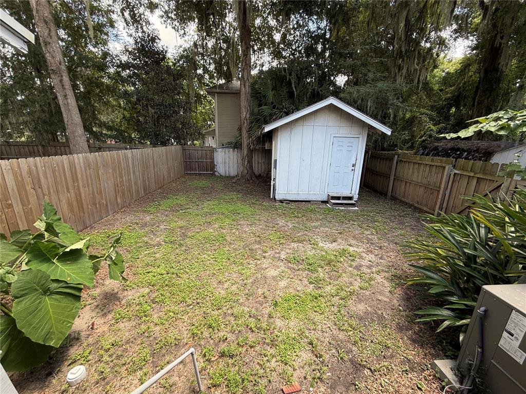 2523 Northwest 6th Street, Unit 1 Gainesville, FL 32609 - Photo 7 of 7 a view of a backyard with a plants and large tree