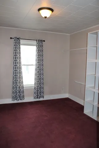 a view of an empty room with a fireplace and a window