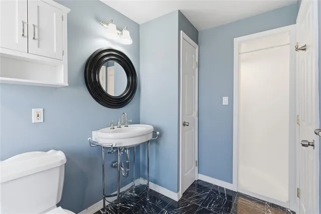 a bathroom with a sink a toilet and a mirror