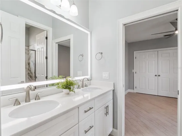 a bathroom with double vanity sinks and a mirror