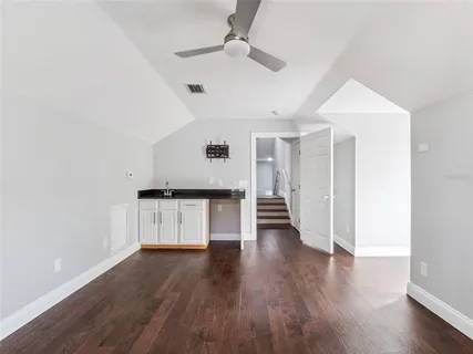 a view of a kitchen with wooden floor and a ceiling fan