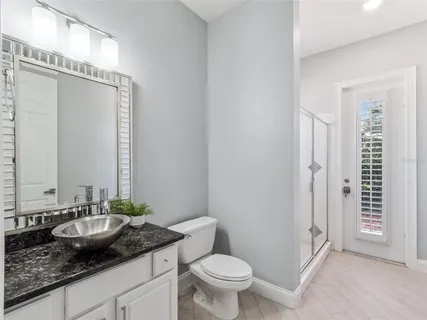 a bathroom with a granite countertop sink toilet and shower