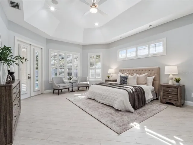 a spacious bedroom with a bed and a chandelier