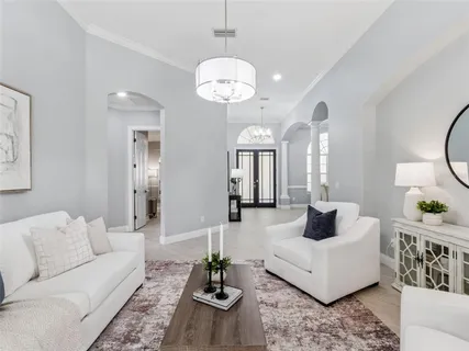 a living room with furniture and a chandelier
