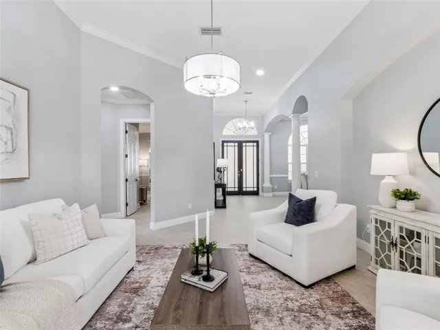 a living room with furniture and a chandelier