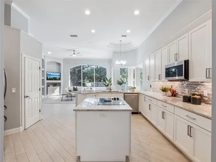 a kitchen with stainless steel appliances kitchen island granite countertop a stove and a sink