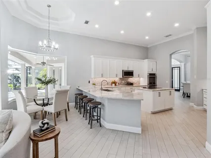 a kitchen with counter top space a sink appliances and dining table
