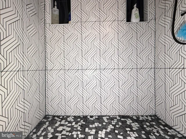 a bed sitting in a bedroom next to a window and a chandelier