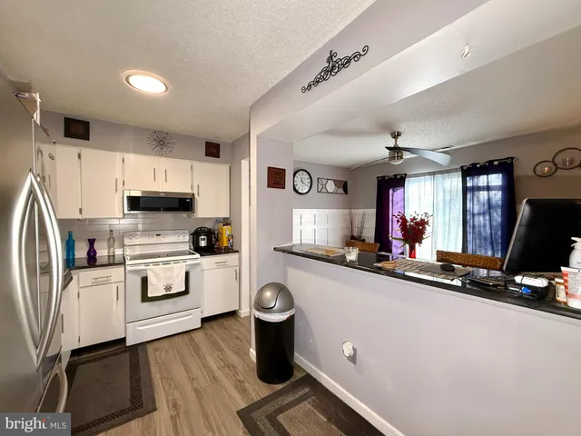 a kitchen with sink a microwave and cabinets