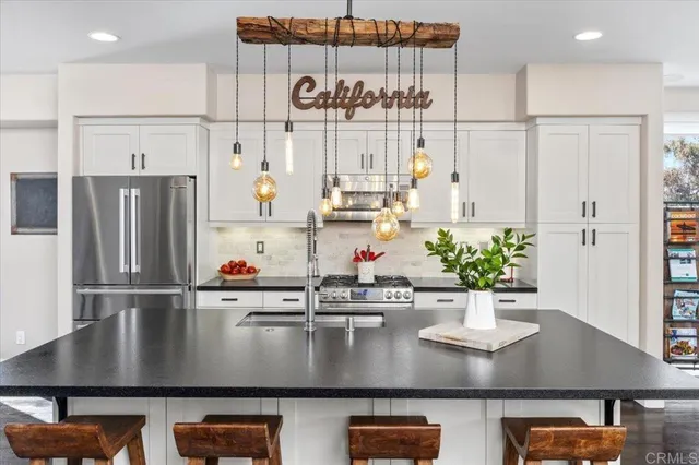 a view of kitchen with stainless steel appliances granite countertop refrigerator sink and cabinets