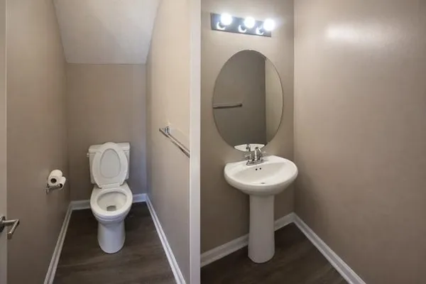 a bathroom with a toilet sink and mirror