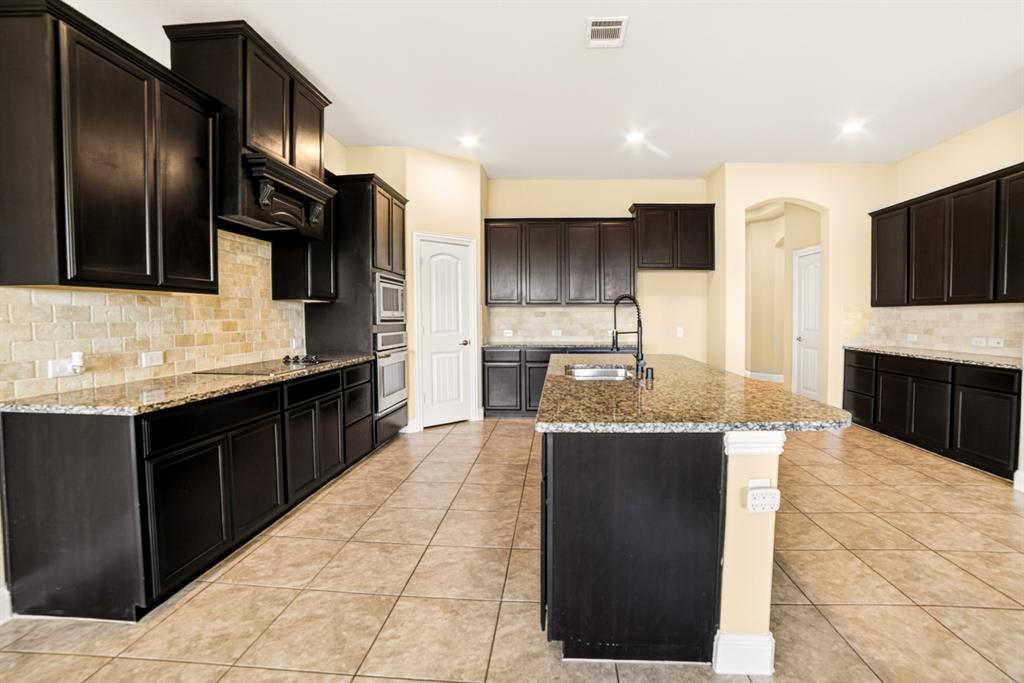 552 Winnetka Drive Oak Point, TX 75068 - Photo 18 of 40 a large kitchen with kitchen island granite countertop a large counter top stainless steel appliances and cabinets